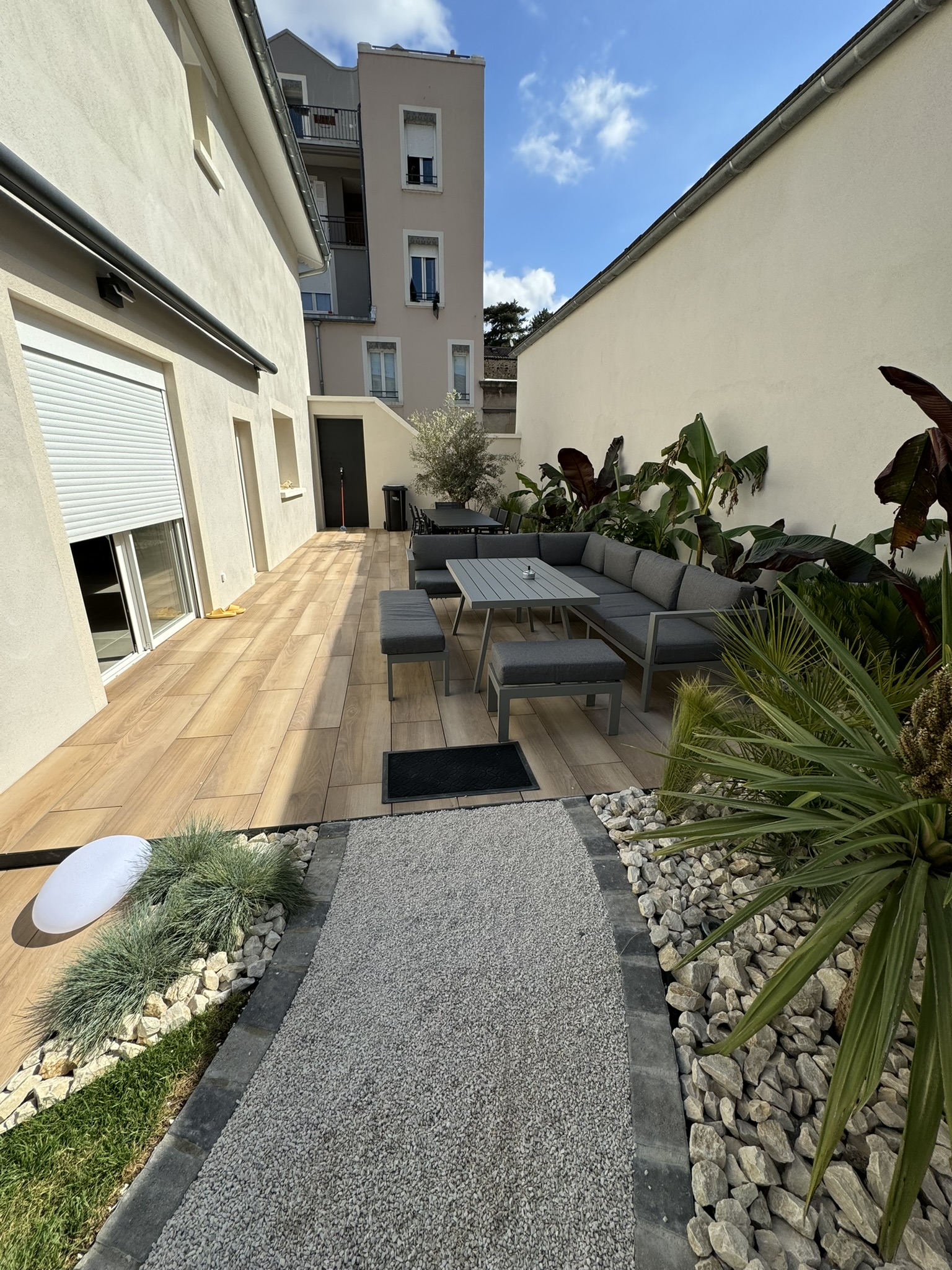 Terrasse en bois réalisée par Rodet Paysages avec salon de jardin moderne