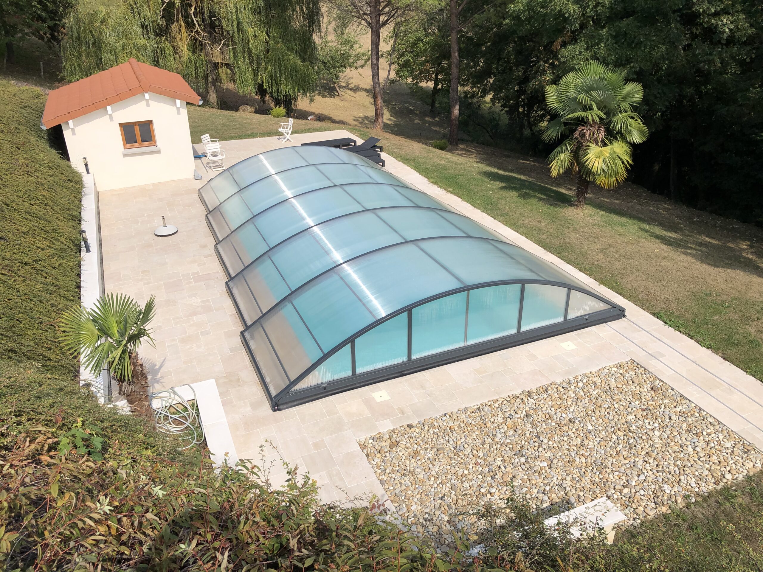Abri de piscine télescopique installé sur une piscine extérieure