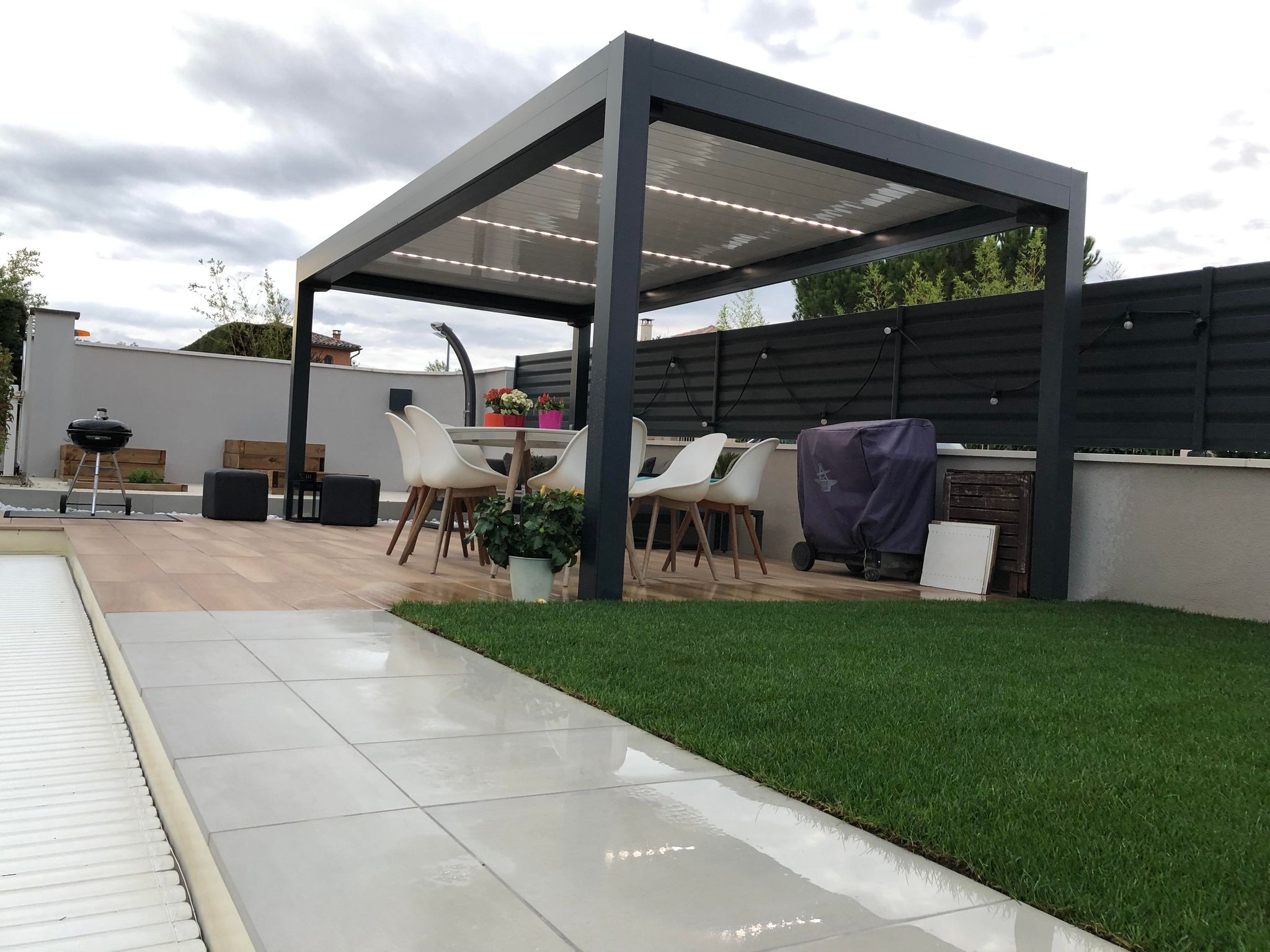 Pergola bioclimatique et carport en bois installés pour un espace ombragé