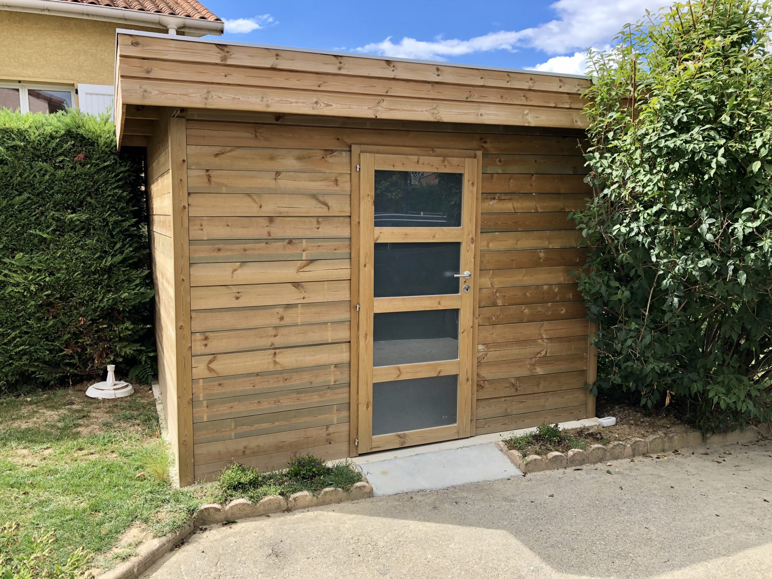 Abri de jardin en bois conçu par Rodet Paysages pour le rangement extérieur