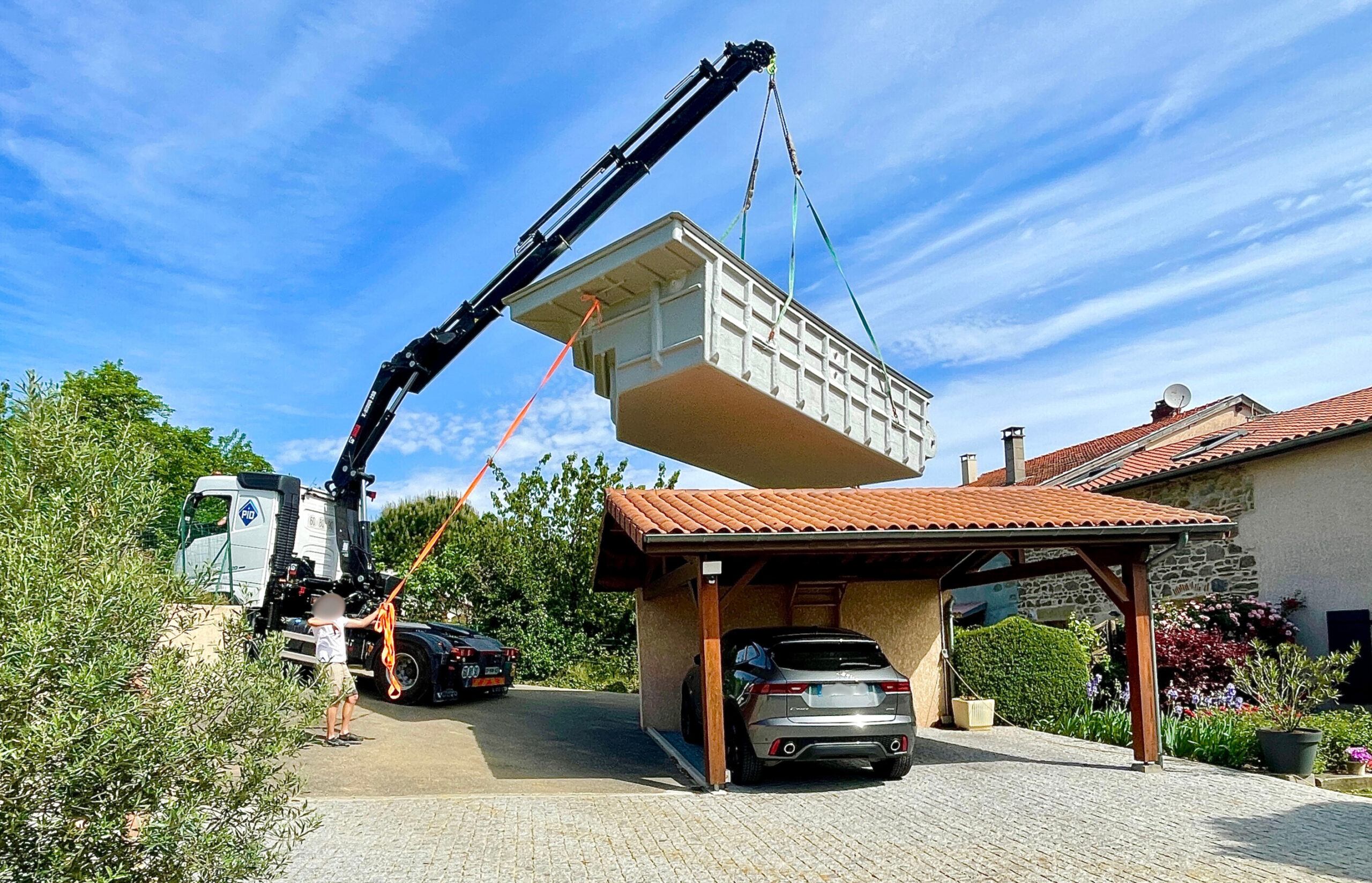Piscine sur-mesure coque installée avec margelle en pierre naturelle